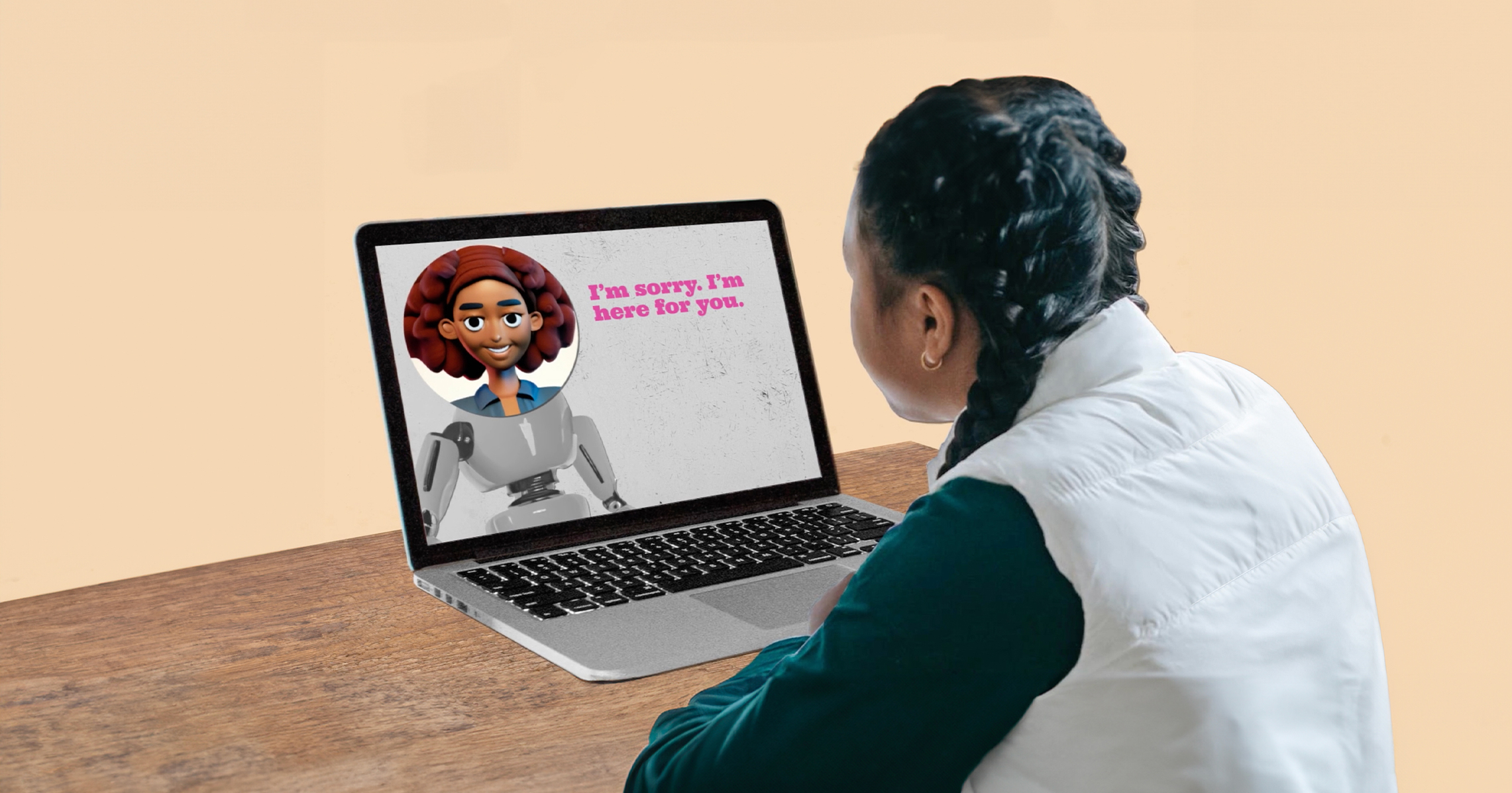A student is sitting a desk with a laptop open with a depiction on the left screen of a robot with an animated face with text on the right screen, "I'm sorry. I'm here for you."