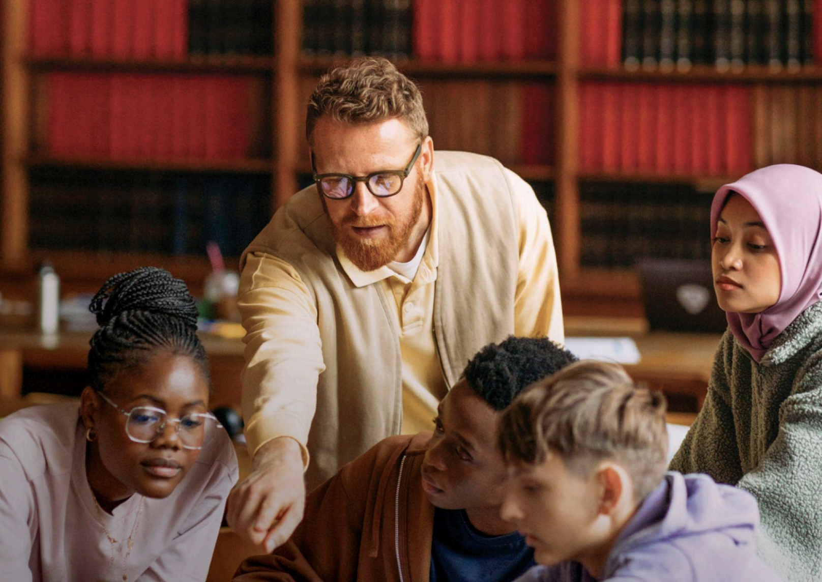 Adult with students in a lobrary