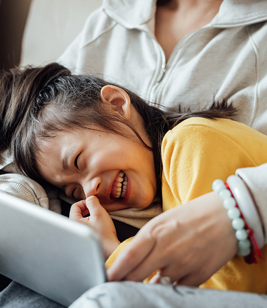 Child with parent looking at a tablet