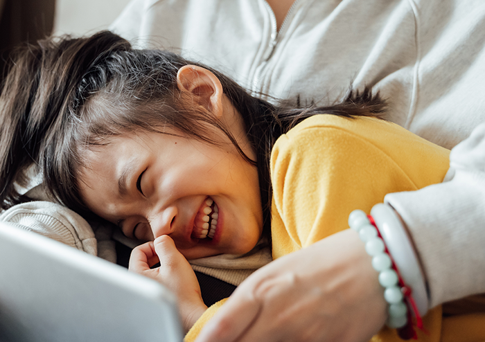 laughing girl in parents lap