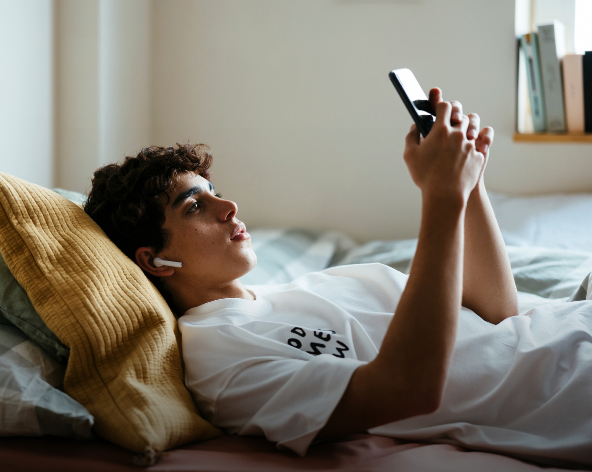 Teen boy laying down with cell phone